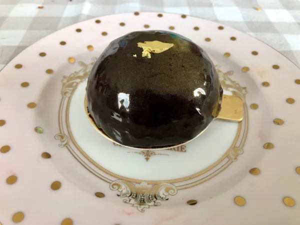 Mousse caramel avec insert fraises fraiches sur biscuit Joconde. Glaçage mirroir chocolat.